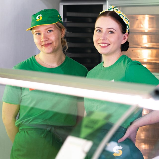 Two smiling sandwich artists