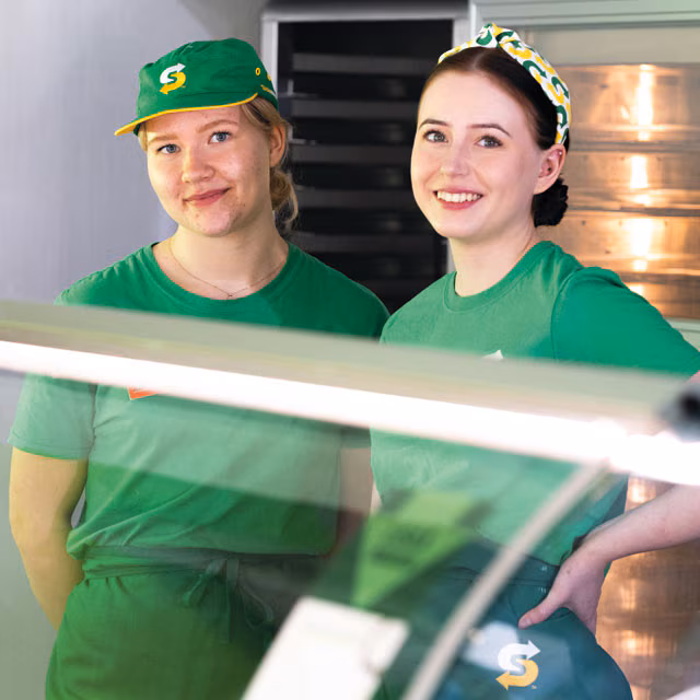 Two smiling sandwich artists
