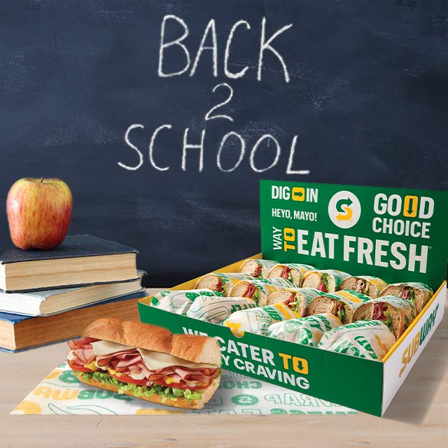 Catering Box with Subs, Single Sub, and a Stack of Books with a Red Apple