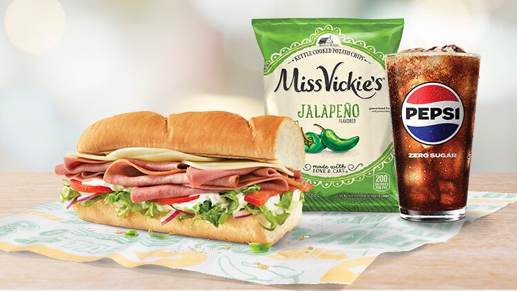 Six-inch Cold Cut Combo, Lay's chips and a glass of Pepsi on a Subway wrapper.