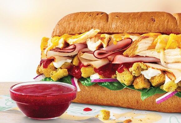 Sub de seis pulgadas TurHamKen junto a un ramequín de salsa de arándanos.